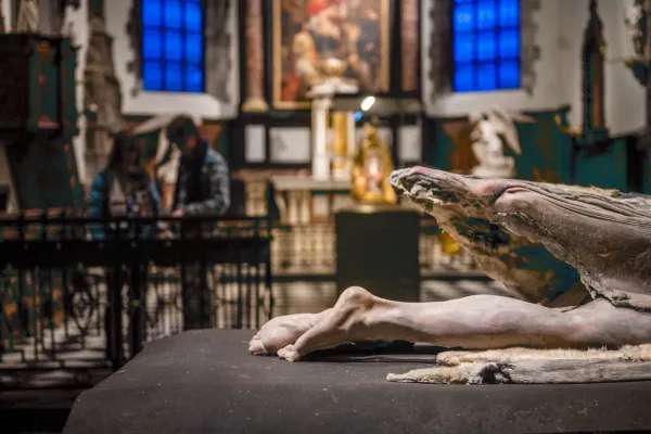 Kerk van het Museum Sint-Janshospitaal, met op de voorgrond een deel van het hedendaags kunstwerk “Liggende-Arcangelo II”, van Berlinde De Bruyckere.